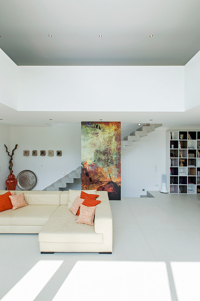 This is an example of a contemporary open concept family room in Other with white walls.