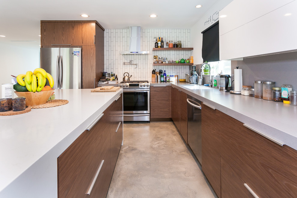 Design ideas for a mid-sized modern l-shaped open plan kitchen in Los Angeles with an undermount sink, flat-panel cabinets, medium wood cabinets, quartzite benchtops, white splashback, subway tile splashback, stainless steel appliances, cement tiles, with island, brown floor and white benchtop.