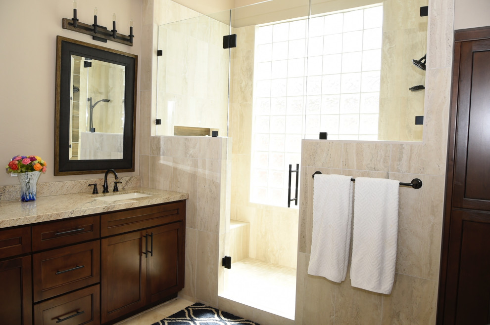 Design ideas for a mid-sized contemporary master bathroom in Phoenix with shaker cabinets, brown cabinets, beige tile, porcelain tile, beige walls, travertine floors, an undermount sink, granite benchtops, beige floor, a hinged shower door, beige benchtops, a shower seat, a double vanity and a built-in vanity.