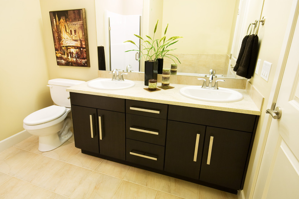 Design ideas for a small contemporary master bathroom in Vancouver with a drop-in sink, flat-panel cabinets, dark wood cabinets, granite benchtops, an alcove tub, a shower/bathtub combo, a one-piece toilet, black tile, ceramic tile, beige walls and ceramic floors.