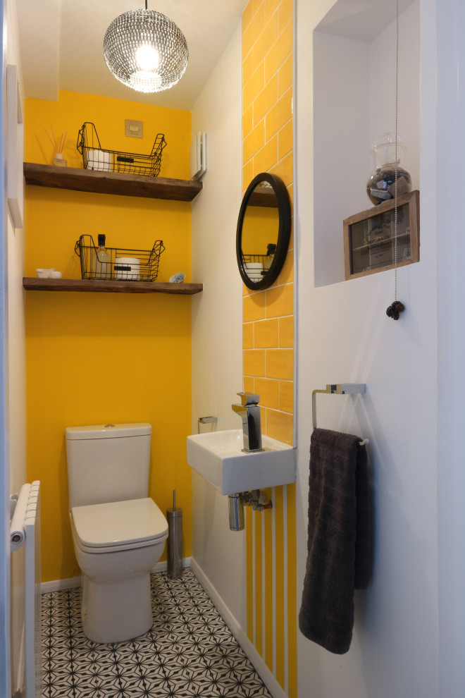 Idéer för att renovera ett litet funkis toalett, med en toalettstol med hel cisternkåpa, gul kakel, keramikplattor, gula väggar, klinkergolv i keramik, ett väggmonterat handfat och svart golv