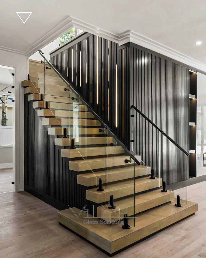 Design ideas for a large modern glass straight staircase in Orlando with metal railing and wood walls.