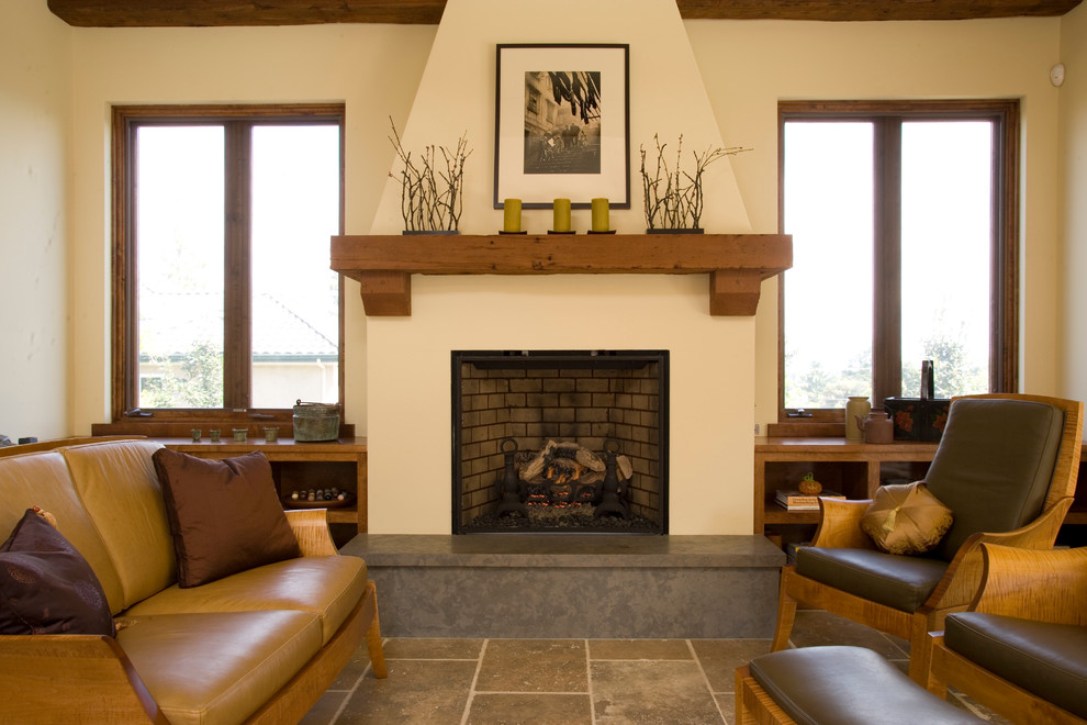 Photo of a mediterranean living room in San Francisco with beige walls, a standard fireplace and travertine floors.