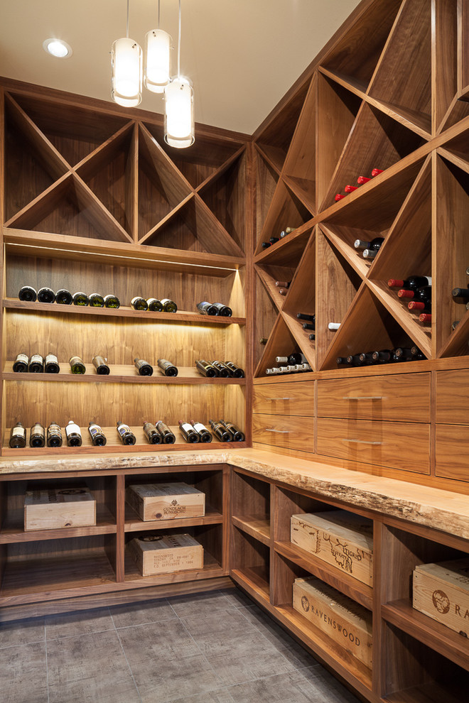 Photo of a mid-sized contemporary wine cellar in Seattle with porcelain floors, storage racks and grey floor.