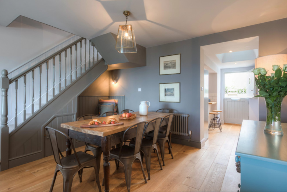 Design ideas for a small transitional open plan dining in Cornwall with grey walls, light hardwood floors and brown floor.