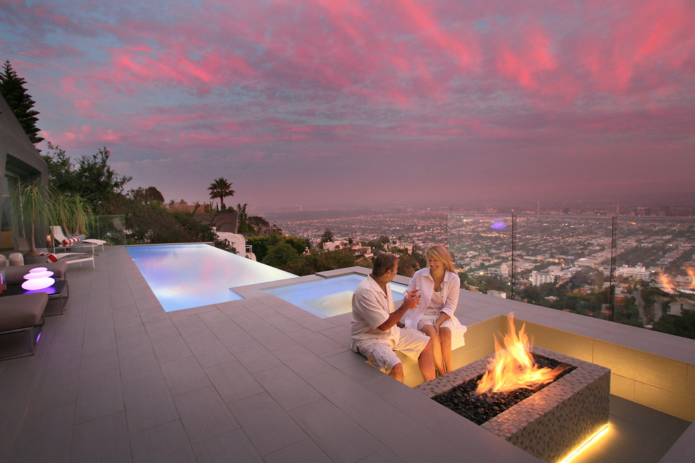 This is an example of a small modern backyard rectangular infinity pool in Los Angeles with a hot tub and tile.