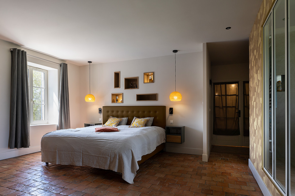 На фото: большая хозяйская спальня в современном стиле с бежевыми стенами, полом из терракотовой плитки, коричневым полом и обоями на стенах