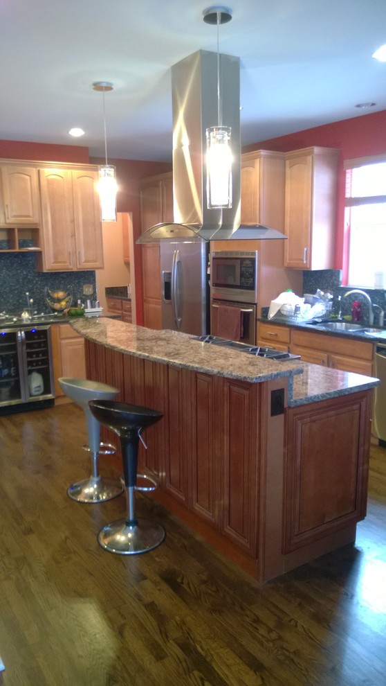 Mid-sized transitional galley medium tone wood floor eat-in kitchen photo in Chicago with a double-bowl sink, raised-panel cabinets, medium tone wood cabinets, granite countertops, stainless steel appliances and an island