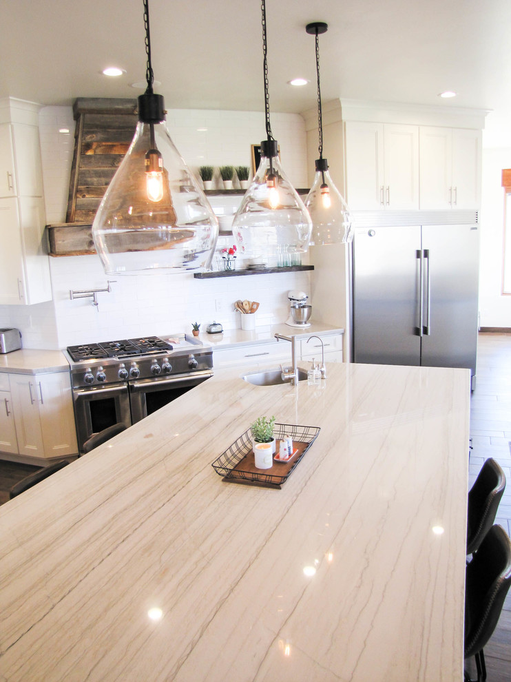 Kitchen - large transitional porcelain tile and brown floor kitchen idea in Phoenix with white backsplash, subway tile backsplash, stainless steel appliances and an island