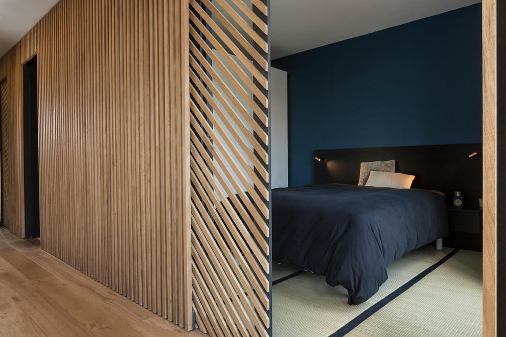 This is an example of a mid-sized contemporary master bedroom in Paris with blue walls, tatami floors, no fireplace and white floor.