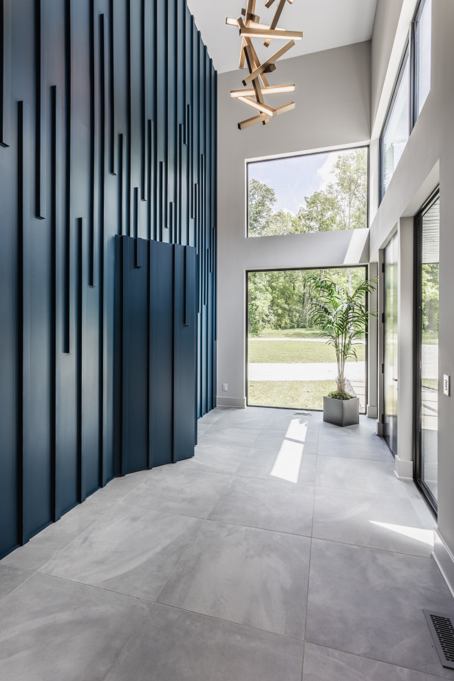 Photo of a contemporary front door in Indianapolis with blue walls, porcelain flooring, grey floors and wood walls.