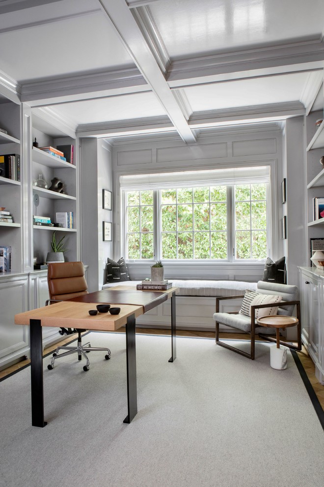 Example of a large transitional freestanding desk home office library design in New York with white walls