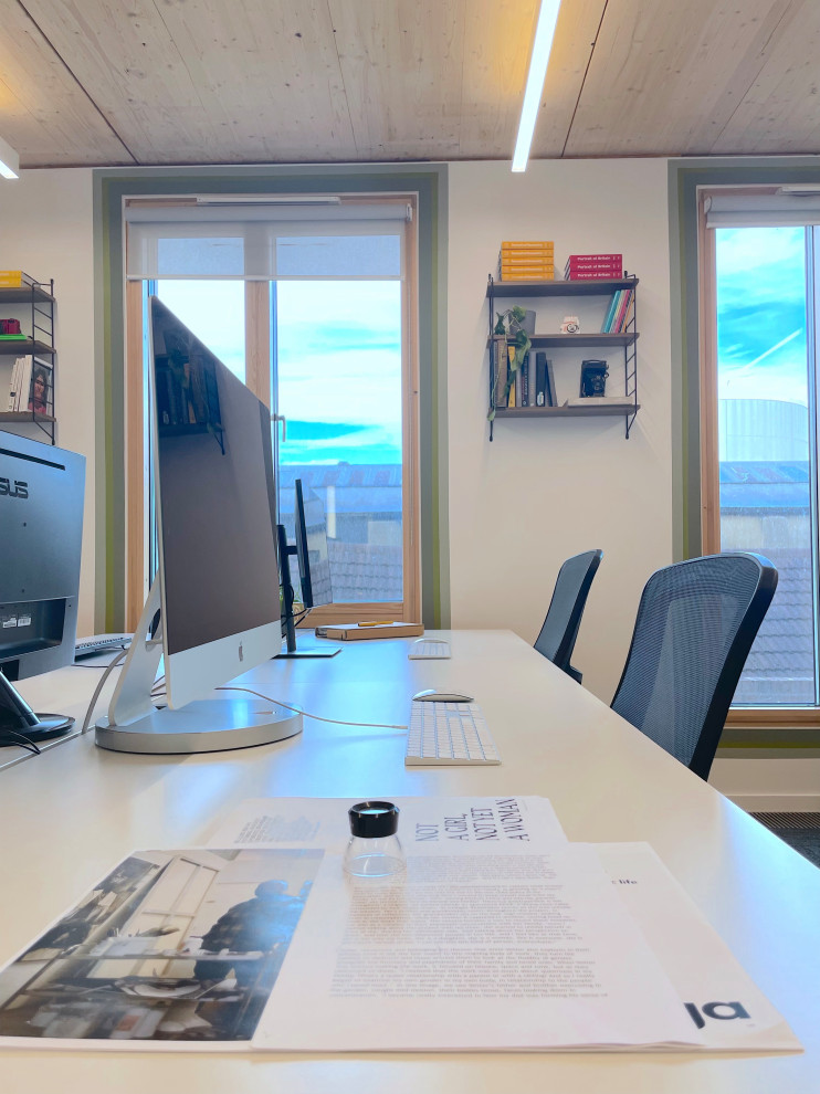 Cette image montre un très grand bureau vintage avec un mur vert et un bureau indépendant.