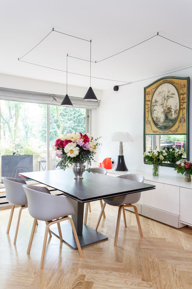 Inspiration for a small scandinavian open plan dining in Paris with white walls, light hardwood floors, no fireplace and beige floor.
