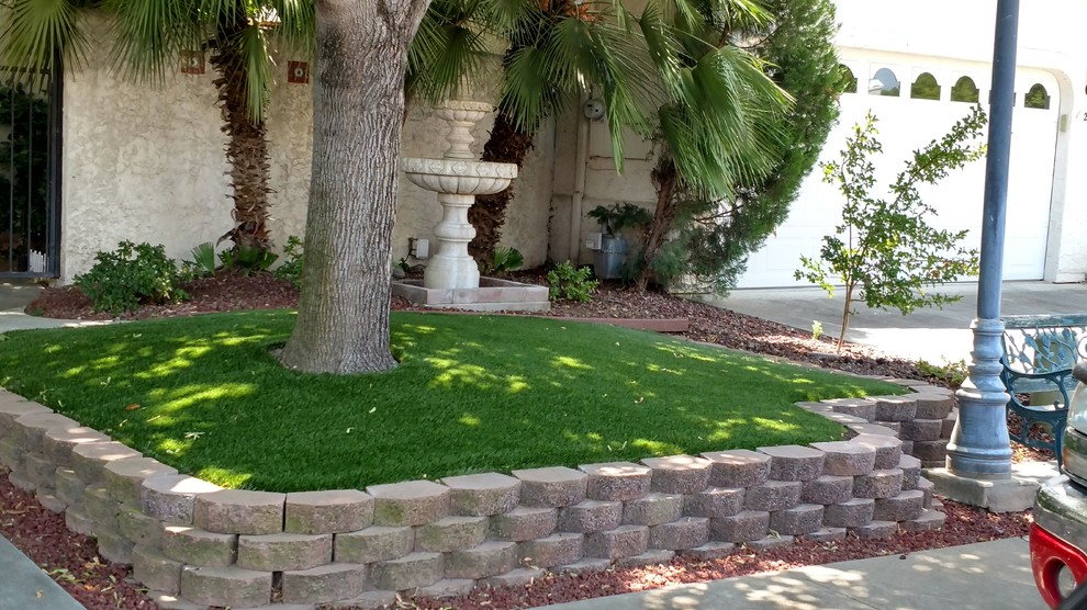 Inspiration for a mid-sized traditional front yard garden in Other with a retaining wall and gravel.