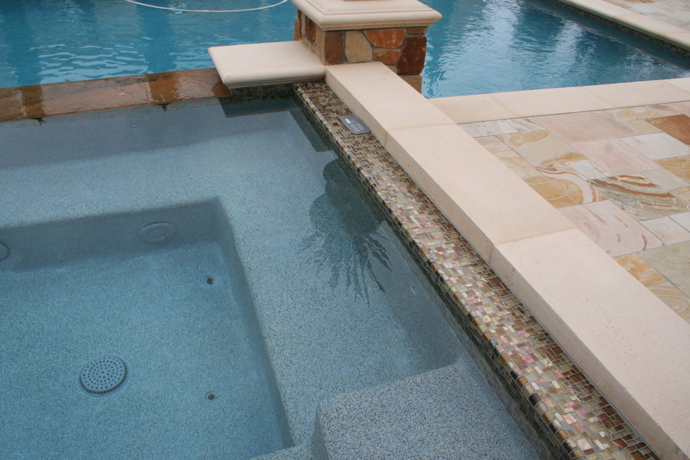 This is an example of a large mediterranean back swimming pool in Los Angeles with natural stone paving.