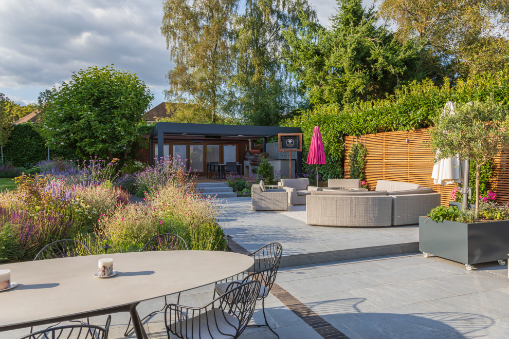 Immagine di un giardino xeriscape design esposto in pieno sole di medie dimensioni e dietro casa in estate con pavimentazioni in mattoni e recinzione in legno