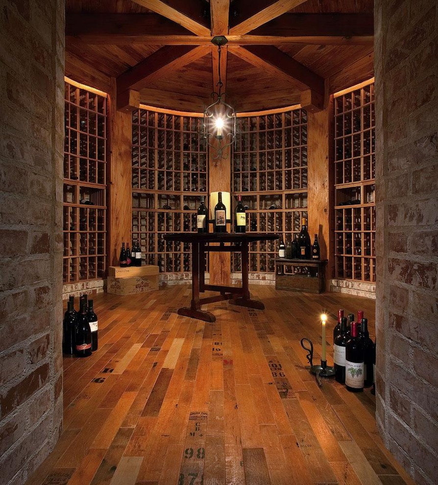Inspiration for a large mediterranean wine cellar in Orange County with dark hardwood floors and storage racks.