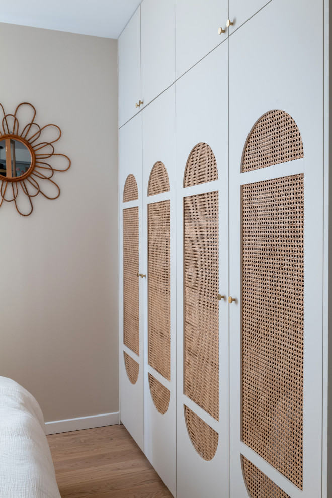 Modelo de dormitorio principal escandinavo pequeño con paredes marrones, suelo de madera clara y suelo marrón