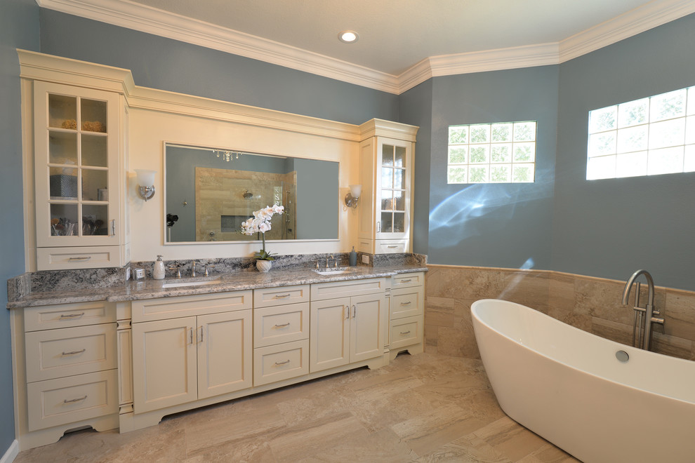 Inspiration for a large transitional master bathroom in Orlando with shaker cabinets, white cabinets, a freestanding tub, an alcove shower, beige tile, porcelain tile, blue walls, porcelain floors, an undermount sink, granite benchtops, beige floor and an open shower.