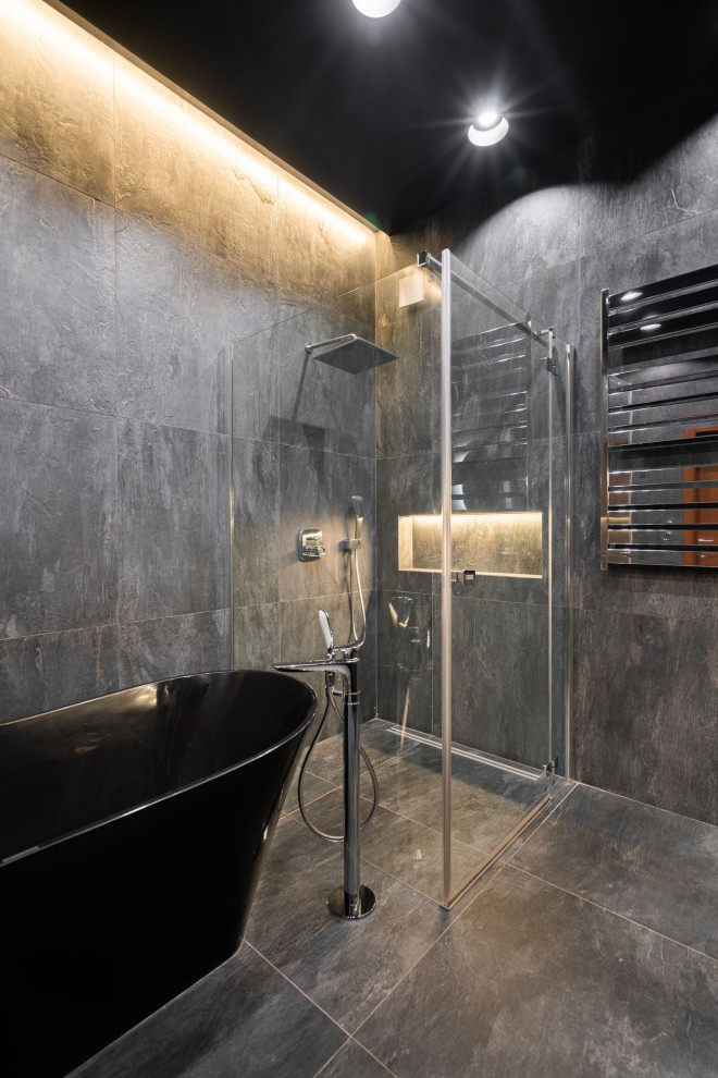 Пример оригинального дизайна: большая ванная комната в современном стиле с плоскими фасадами, черными фасадами, отдельно стоящей ванной, угловым душем, раздельным унитазом, керамогранитной плиткой, серыми стенами, полом из керамогранита, душевой кабиной, врезной раковиной, столешницей из искусственного камня, серым полом, душем с распашными дверями, серой столешницей, тумбой под одну раковину и подвесной тумбой