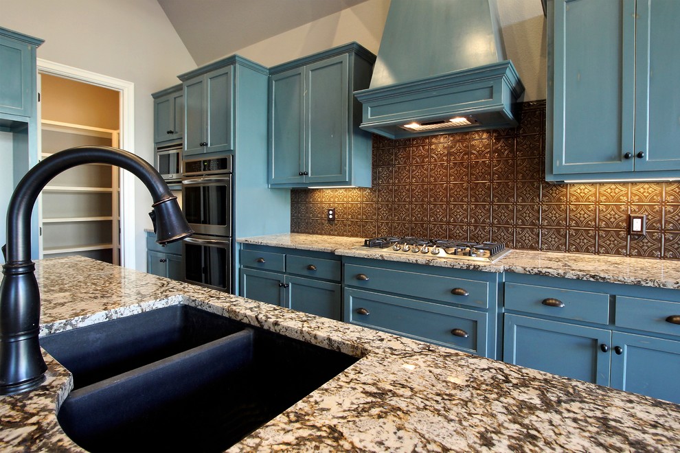 Inspiration for a mid-sized transitional l-shaped dark wood floor eat-in kitchen remodel with a double-bowl sink, recessed-panel cabinets, blue cabinets, glass countertops, brown backsplash, cement tile backsplash, stainless steel appliances and an island