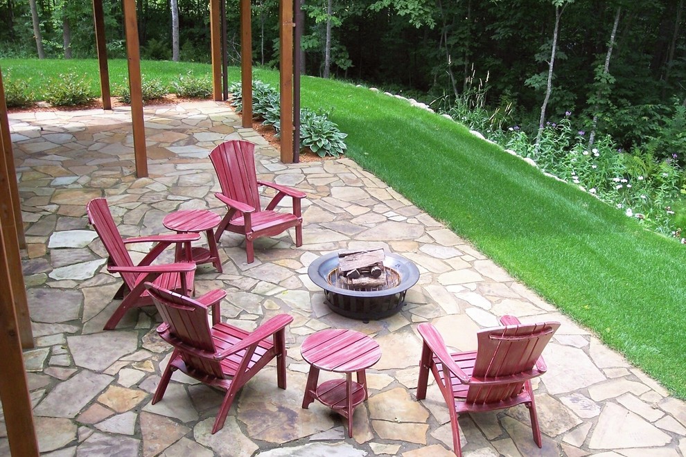 Design ideas for a mid-sized country backyard patio in Minneapolis with natural stone pavers and no cover.