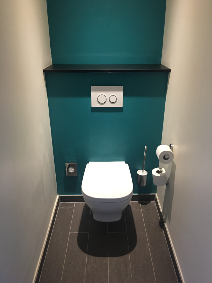 На фото: маленький туалет в стиле модернизм с инсталляцией, синими стенами, полом из плитки под дерево и коричневым полом для на участке и в саду