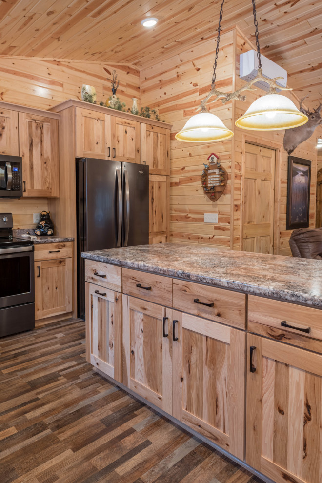 This is an example of a mid-sized country l-shaped eat-in kitchen in Minneapolis with an undermount sink, shaker cabinets, medium wood cabinets, laminate benchtops, stainless steel appliances, linoleum floors, with island, multi-coloured floor and turquoise benchtop.