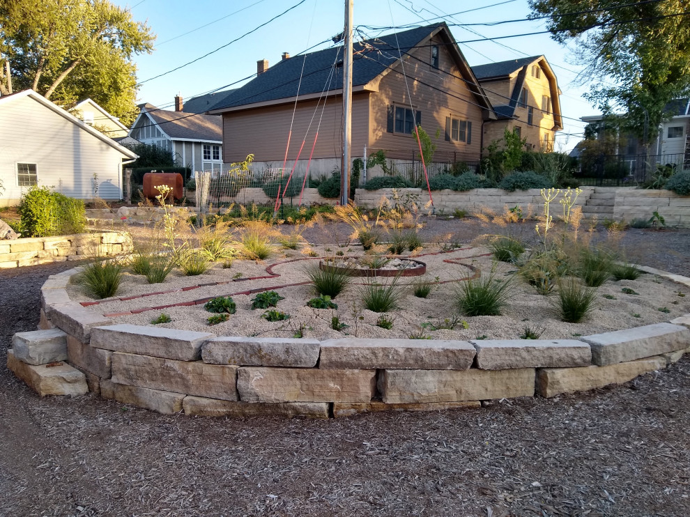 This is an example of a mid-sized backyard full sun xeriscape in Cedar Rapids with with raised garden bed and gravel.