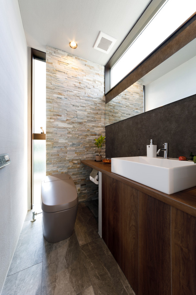 Aménagement d'un WC et toilettes avec un carrelage beige, un mur blanc, un sol gris, un plan de toilette marron, meuble-lavabo encastré, un plafond en lambris de bois et du lambris de bois.