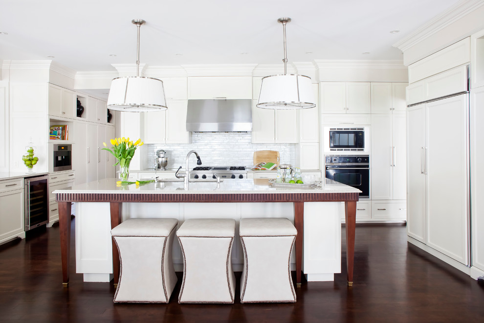 Kitchen - transitional dark wood floor kitchen idea in Montreal with an undermount sink, shaker cabinets, white cabinets, quartzite countertops, white backsplash, ceramic backsplash, an island and paneled appliances