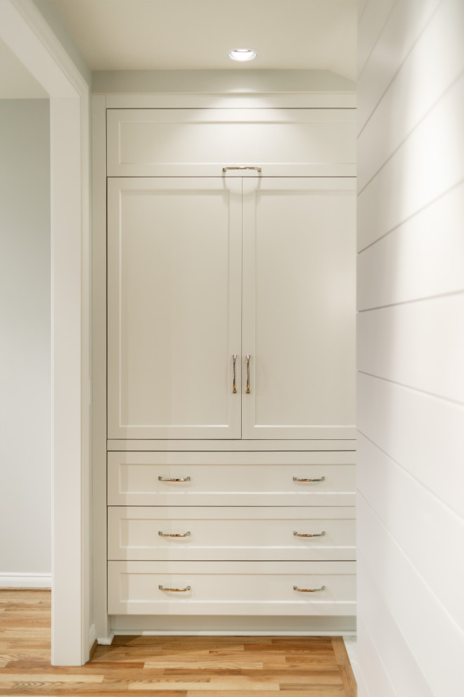 Mid-sized beach style storage and wardrobe in Seattle with shaker cabinets, white cabinets, medium hardwood floors and vaulted.