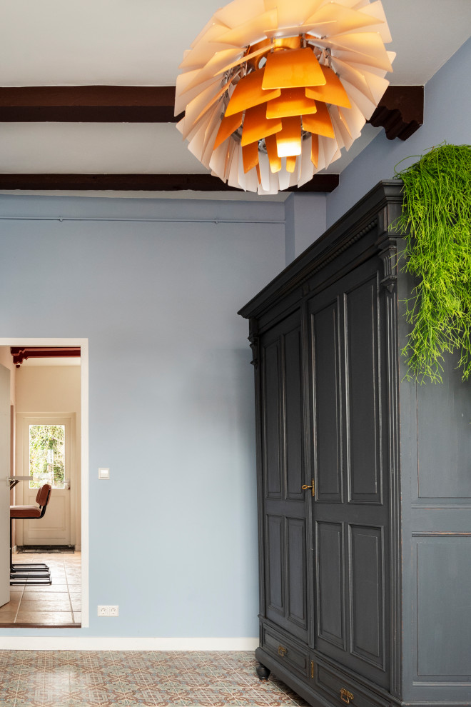 Exempel på en liten eklektisk hall, med blå väggar, klinkergolv i keramik och flerfärgat golv