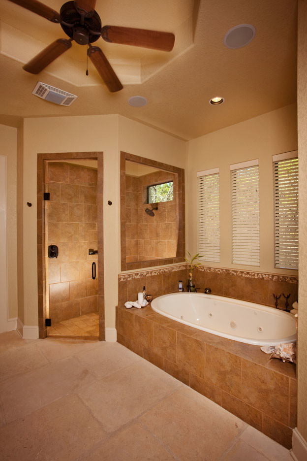 Photo of a large modern master bathroom in Austin with a vessel sink, dark wood cabinets, granite benchtops, a corner shower, beige tile and beige walls.