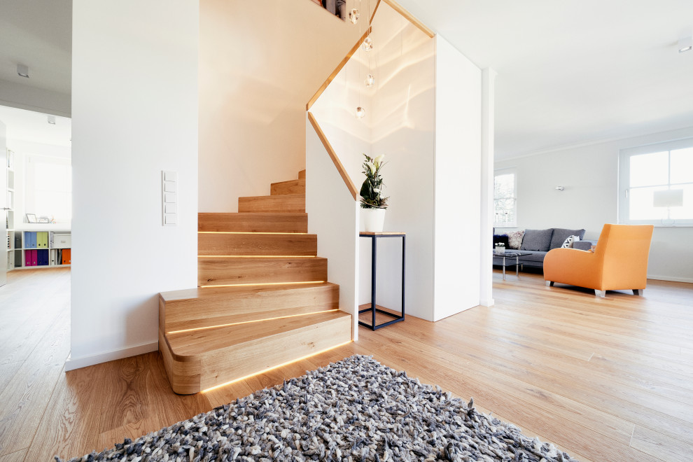 Small contemporary wood curved staircase in Dortmund with wood risers and wood railing.