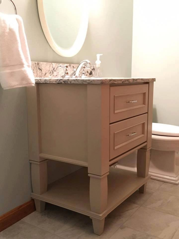 Photo of a small traditional master bathroom in Boston with furniture-like cabinets, white cabinets, a two-piece toilet, gray tile, porcelain tile, beige walls, porcelain floors, a drop-in sink, granite benchtops, grey floor, a hinged shower door and black benchtops.