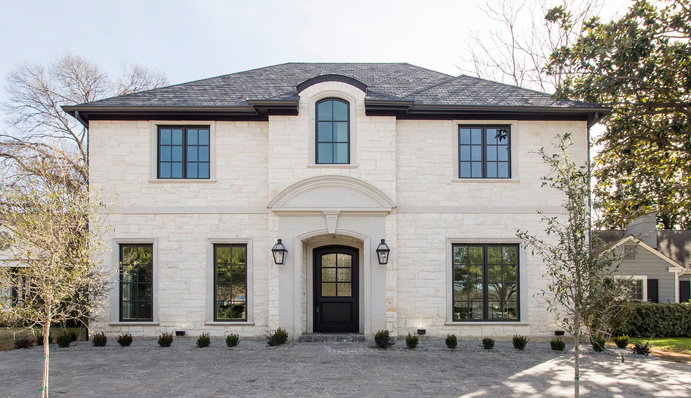 Transitional two-storey white house exterior in Dallas with stone veneer, a hip roof and a shingle roof.