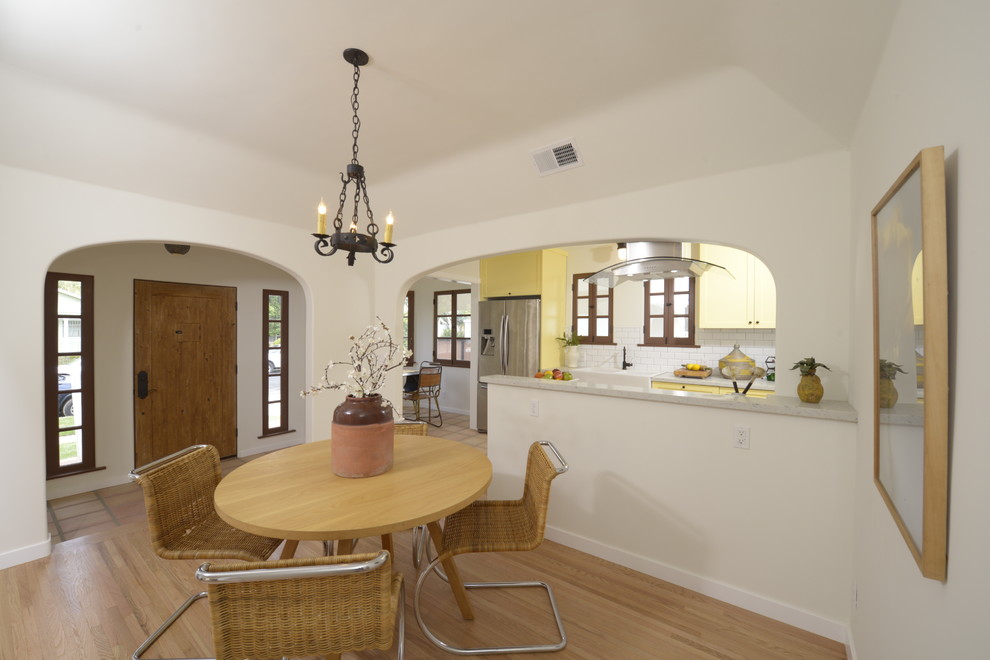 Design ideas for a mid-sized mediterranean kitchen/dining combo in Los Angeles with white walls and light hardwood floors.