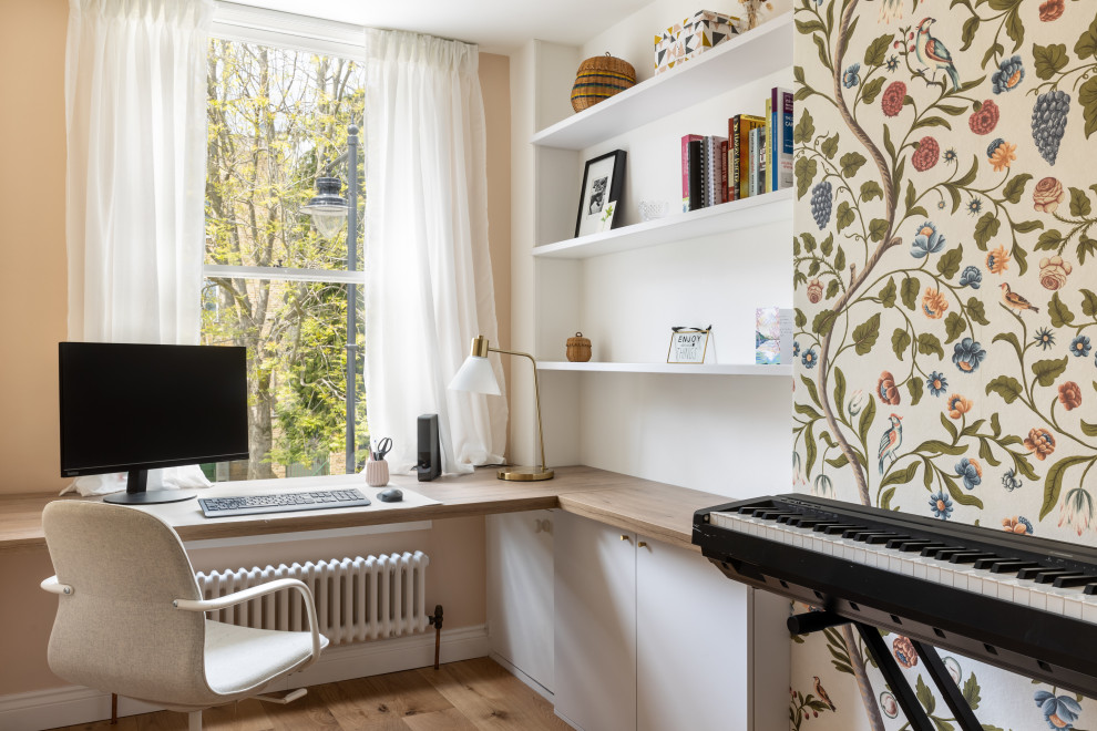 This is an example of a medium sized contemporary study in London with multi-coloured walls, no fireplace, a freestanding desk, a wallpapered ceiling and wallpapered walls.