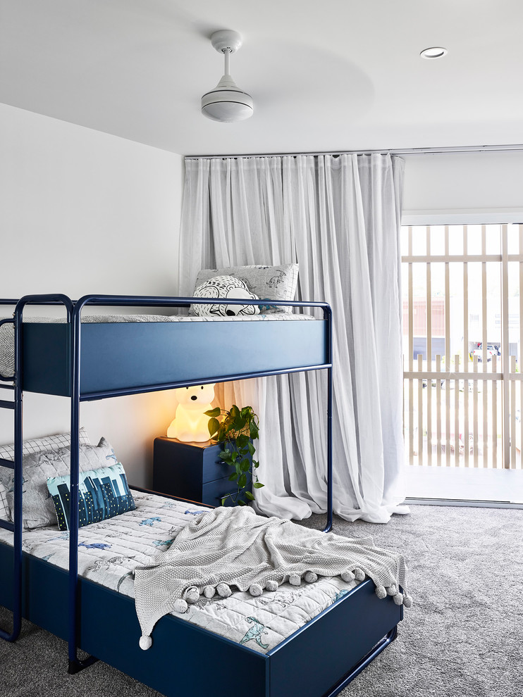 Photo of a beach style gender-neutral kids' bedroom for kids 4-10 years old in Sunshine Coast with white walls, carpet and grey floor.