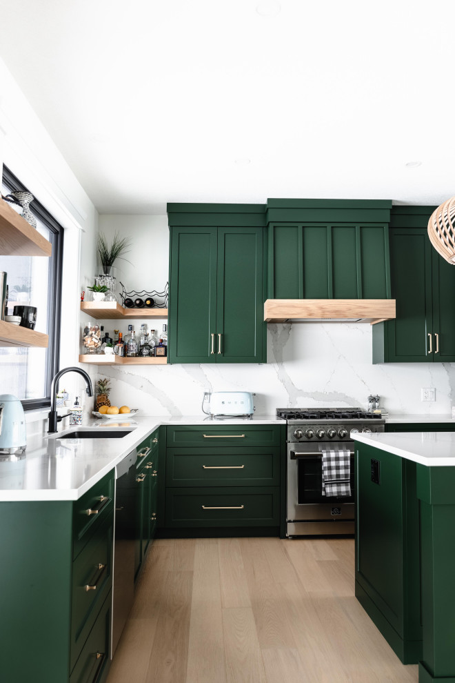Inspiration for a mid-sized country l-shaped open plan kitchen in Toronto with an undermount sink, shaker cabinets, green cabinets, quartz benchtops, white splashback, engineered quartz splashback, stainless steel appliances, light hardwood floors, with island, brown floor and white benchtop.
