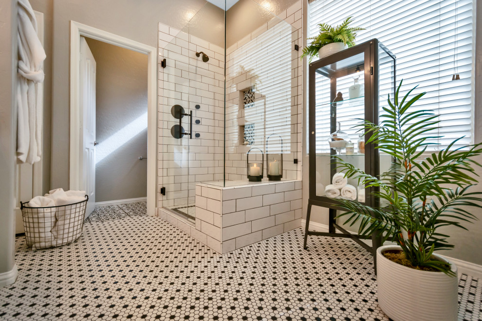 This is an example of a mid-sized transitional master bathroom in Phoenix with shaker cabinets, white cabinets, a corner shower, white tile, subway tile, grey walls, mosaic tile floors, an undermount sink, granite benchtops, white floor, a hinged shower door and black benchtops.