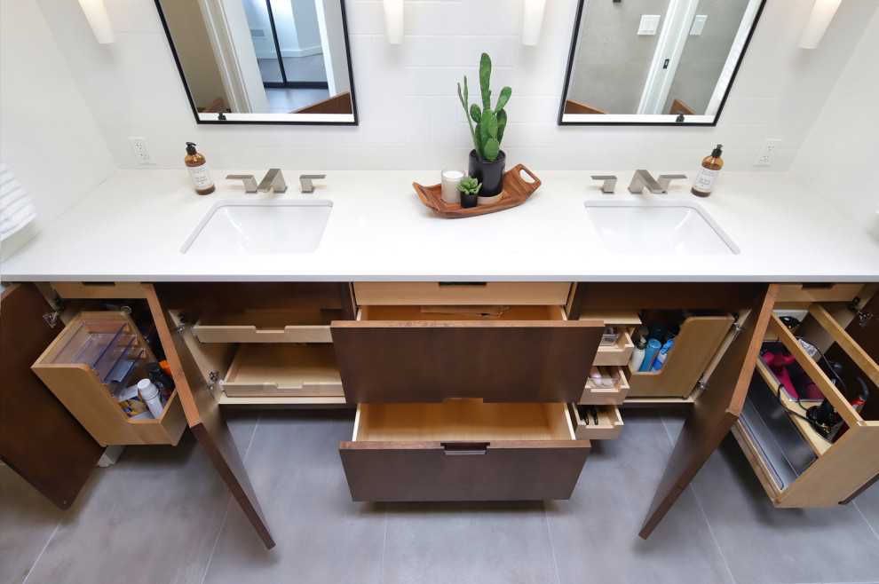 Mid-sized midcentury master bathroom in Phoenix with flat-panel cabinets, medium wood cabinets, a curbless shower, a one-piece toilet, gray tile, porcelain tile, white walls, porcelain floors, an undermount sink, engineered quartz benchtops, grey floor, an open shower, white benchtops, a niche, a double vanity, a built-in vanity and wood walls.