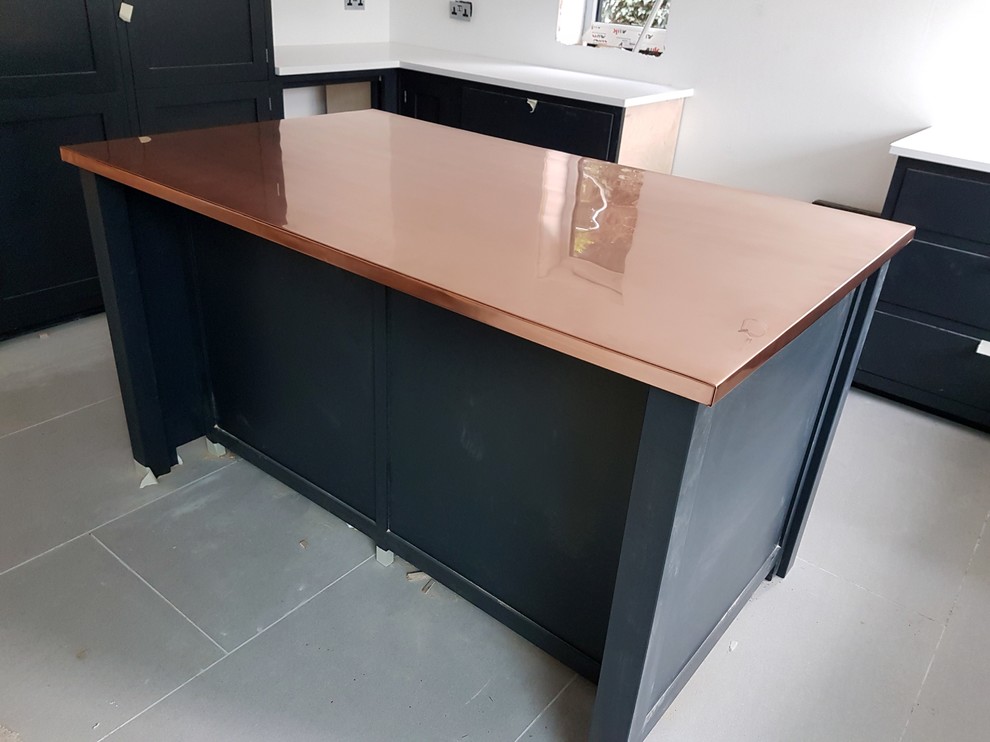 This is an example of a large contemporary kitchen in London with copper benchtops.