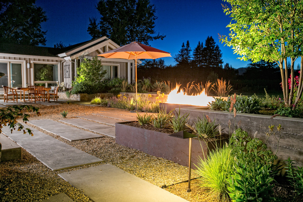 This is an example of a large contemporary backyard garden in San Francisco with a fire feature and gravel.