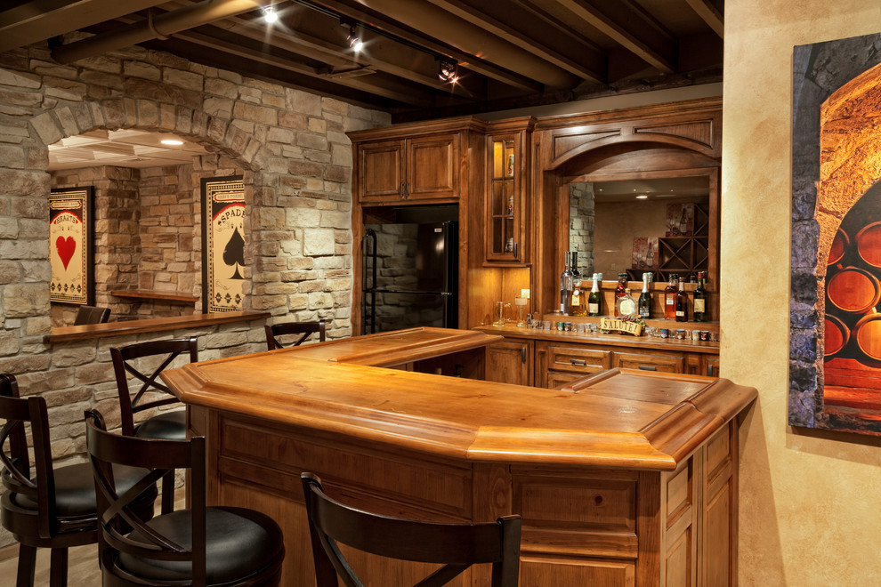 This is an example of a country u-shaped seated home bar in Chicago with raised-panel cabinets, medium wood cabinets, wood benchtops and brown benchtop.
