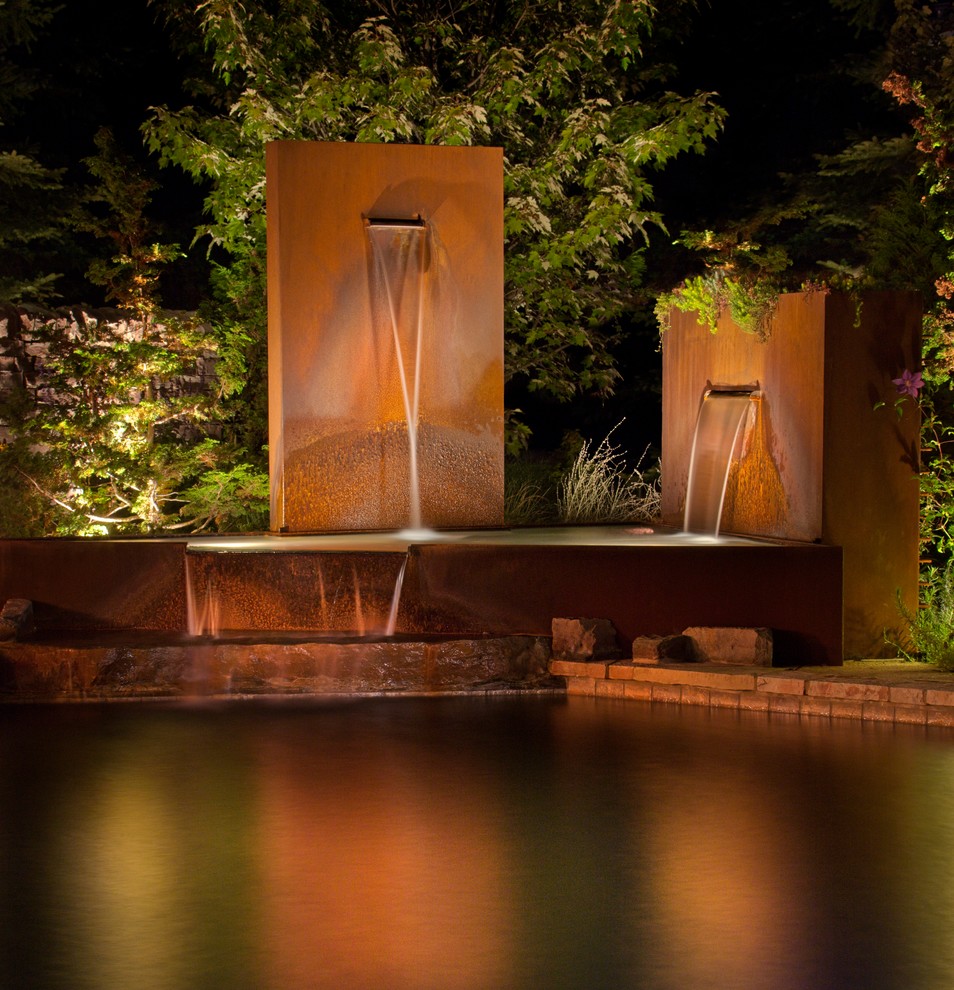 Inspiration for a mid-sized modern backyard stone patio fountain remodel in Detroit