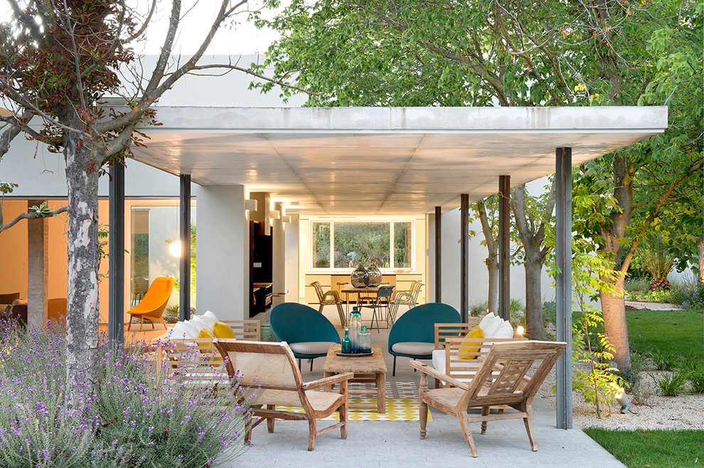 Inspiration for a contemporary backyard patio in Madrid with a roof extension.