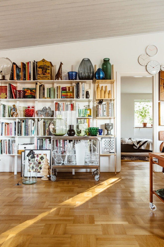 Photo of a midcentury living room in Stockholm with white walls, medium hardwood floors and no fireplace.